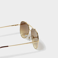 Close-up side view of Bali gold aviator sunglasses with brown gradient lenses