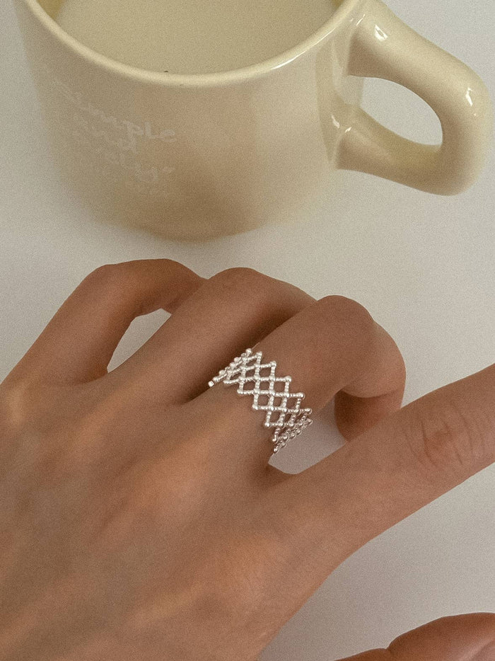 Léandre Silver Weaved Ring – Size 7 on middle finger of lady's hand with coffee mug in background