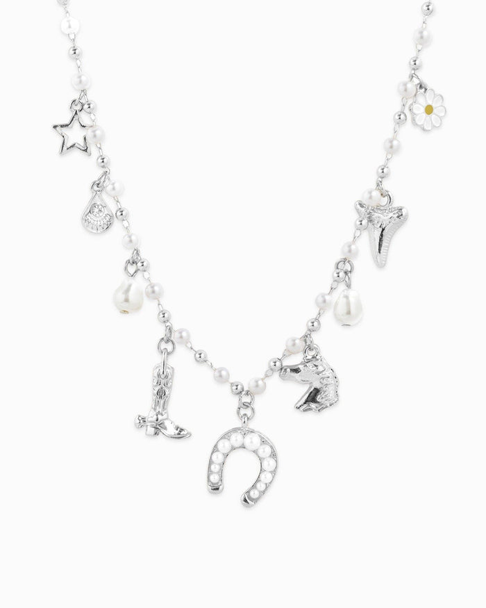 Close up view of silver Western Icon Charm Necklace on white background