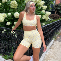 close up of girl standing in athletic outfit with headband leaned against a fence
