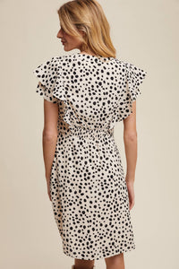 Back view of model wearing ruffled animal polka dot dress with flutter sleeves and gathered waist