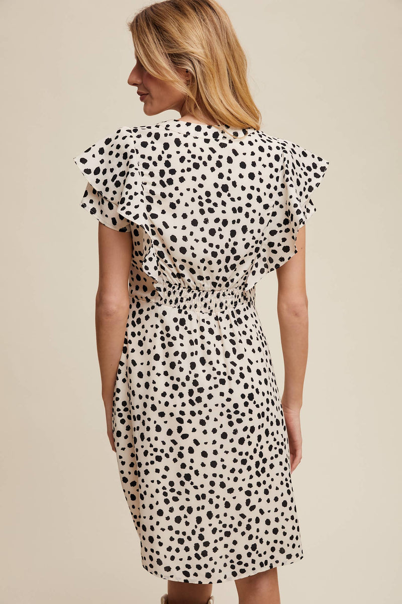Back view of model wearing ruffled animal polka dot dress with flutter sleeves and gathered waist
